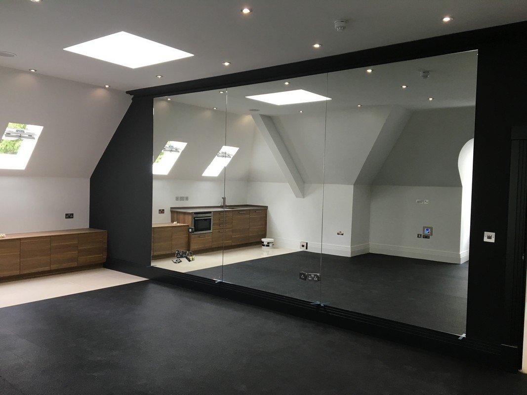 Frameless glass wall dividing loft conversion in East Dulwich
